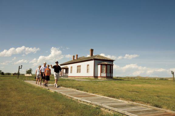 A group of people are walking outside Fort Buford